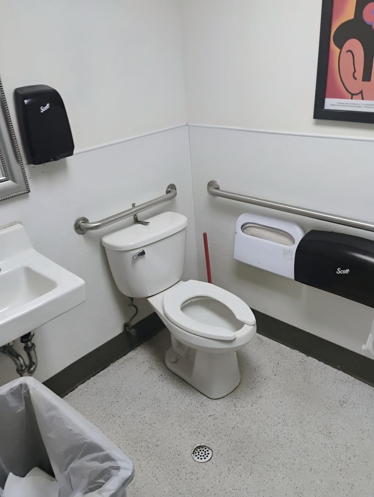 A completed restroom with new fixtures, sink and grab bars installed.